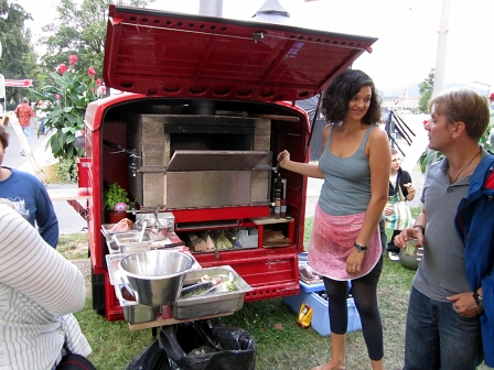 Ein rotes Auto, in das ein Pizzaofen integriert ist.