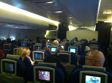 Passagiere in einem Flugzeug mit vielen LCD-Fernsehern