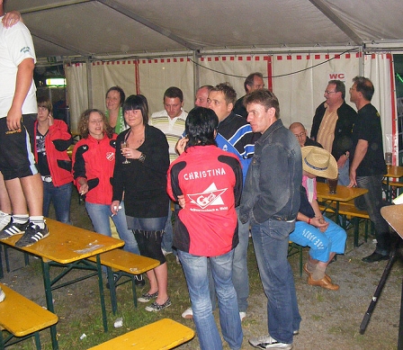 Menschen in einem Zelt mit Bierbänken