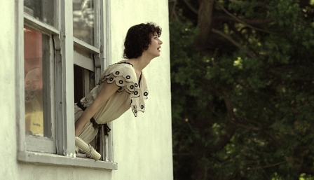 Miranda July lehnt sich aus einem Fenster