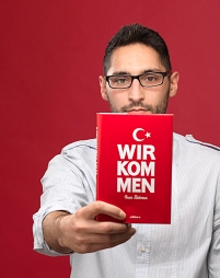 Inan Türkmen hält uns sein Buch entgegen.