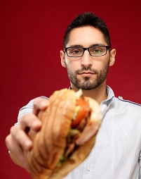 Inan Türkmen hält uns ein Döner Kebap entgegen.