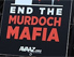 Schild mit Aufschrift: End the Murdoch Mafia