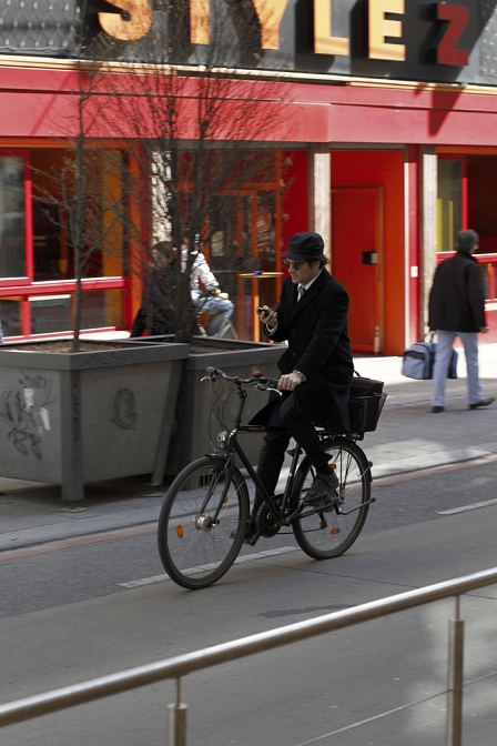 Mann mit Anzug und Hut auf Rad