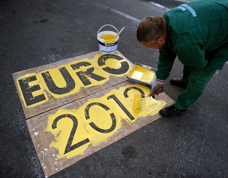 Workers paint a special lane for fans who will drive by cars to Ukraine for Euro 2012 