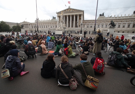 Studierende blockieren sitzend den Ring vor dem Parlament.