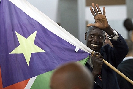 An man from southern Sudan waves his nation's flag 