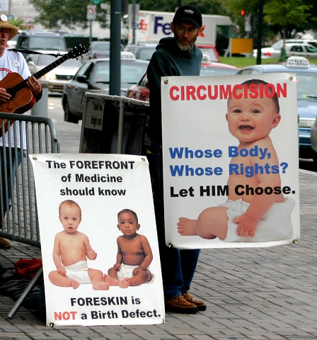 Ein Aktivist gegen Beschneidung mit Plakaten
