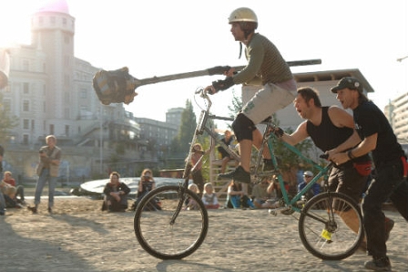 Fahrer auf Tallbike mit Art Lanze in der Hand