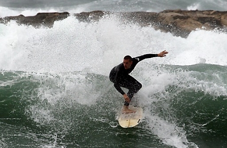  An Israeli surfer rides a wave inside the break-water at a Tel Aviv, Israel beach 