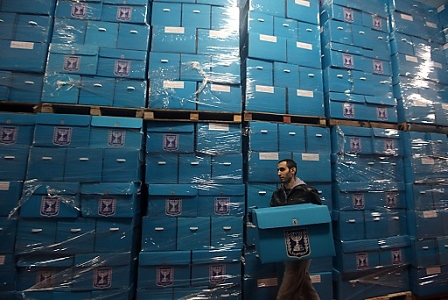 A worker of the Central Election Commission in Israel organizes ballots boxes in preparation for 2013 Israel elections, in Shoham, Israel