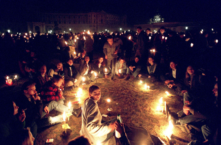 Eine Gruppe von Menschen sitzt in einem Kreis inmitten des Lichtermeers