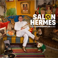 Salon Hermes Sehrsupersampler #Eins, Hermes auf einer alten Couch mit viel Kitsch herum