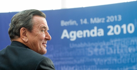 Gerhard Schröder vor einer Tafel mit der Aufschrift "Agenda 2010"