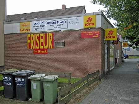 Haus, auf dem ein Schuld "Friseur im Kiosk" hängt