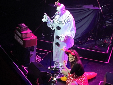 Weißclown von "Puddles Pity Party" auf der Bühne neben einer Frau mit einer Affenmaske