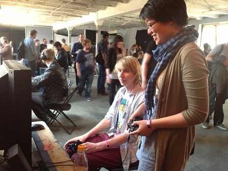 Eine Frau und ein Mann spielen in der Halle der "A MAZE. Indie Connect".