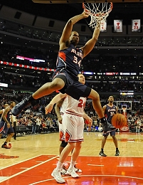  A file picture dated 11 March 2010 shows Atlanta Hawks center Jason Collins (front) hanging from the basket after scoring 