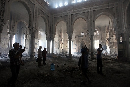 People walk inside the burnt Rabaa Adawiya mosque, the morning after the clearing of the sit-in which was held in and around the mosque, in Cairo, Egypt, 15 August 2013