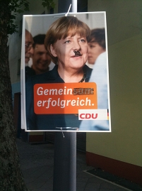 Beschmiertes CDU-Wahlplakat: Angela Merkel mit Hitlerbärtchen