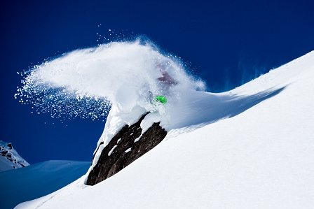 Snowboarder wirbelt Schnee auf