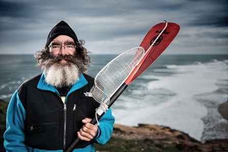 Carlos paddelt, um Müll aus dem Meer zu fischen