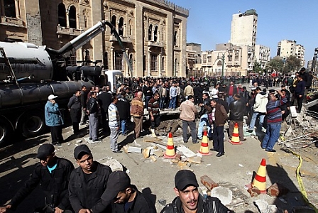 Egyptian police and civilians gather at the site of a car bomb explosion outside police headquarter in Cairo, Egypt, 24 January 2014