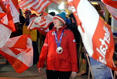 Nicole Hosp mit Olympiamedaille in einem Fahnenmeer