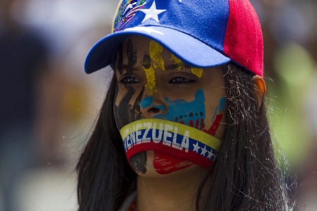 Junge Frau aus Venezuela protestiert, Gesicht beschmiert