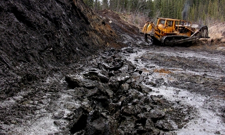 Umgegrabener Landstrich in Kanada und ein stillstehender Bagger