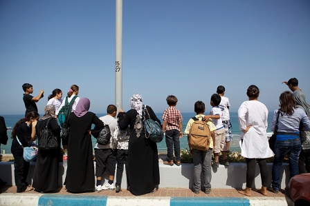 Muslimische Frauen aus der Westbank stehen am Strand und schauen auf das Meer von einem Strand in Tel Aviv aus