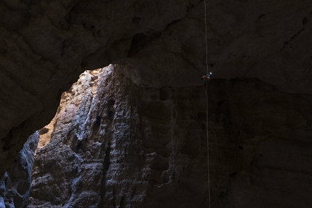 Riesige Höhle, in die sich jemand abseilt