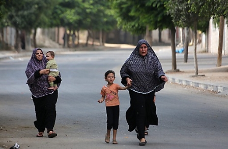 Palestinians women and children flee from their houses in the Al Shejaeiya neighbourhood, during an Israeli military operation in the east Gaza City, 20 July 2014