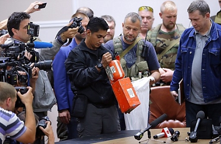 A Malaysian expert checks a black box of the crashed Malaysian Air airliner MH17 in Ukraine, earlier today.