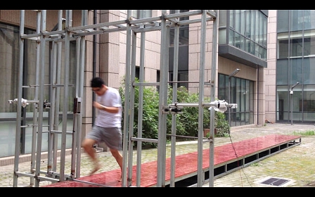 Ein junger Mann läuft durch ein Stahlgerüst. Foto zur Kunstinstallation "The Collider".