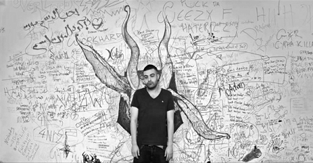 Abyusif vor einer Wand voller Grafitti