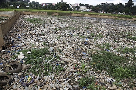 Plastic bottles and bags litter a verge of a canal leading to a lagoon in Abidjan, Ivory Coast, 12 September 2013. 