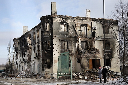 Local residents pass a destroyed building in the eastern Ukrainian city of Uglegorsk.