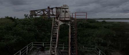 Filmstill aus "Parabellum": eine verkommene technische Anlage in einer grünen Landschaft