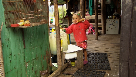 Kleines Mädchen schaut zu Kanarienvögeln im Käfig auf und steht in einem improvisierten Badezimmer. Filmstill aus "Stále Spolu"