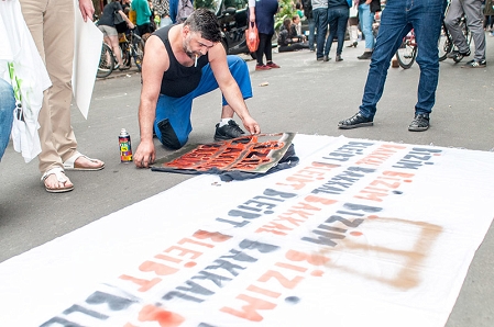 Ein Protestierender mal ein Plakat: Bizim Bakkal bleibt