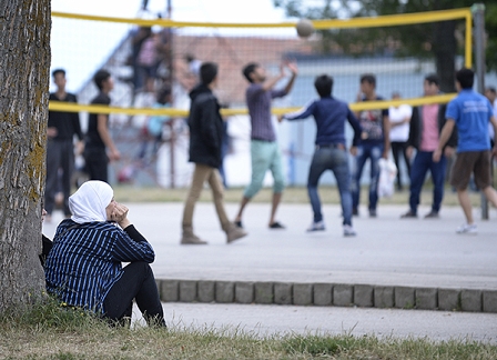 Eine Frau sieht im Flüchtlingslager Traiskirchen einer Gruppe beim Volleyballspielen zu. 