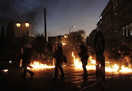 Greek policemen try to avoid a petrol bombs thrown by protesters during a demonstration against planned austerity measures, Athens, Greece, 15 July 2015.