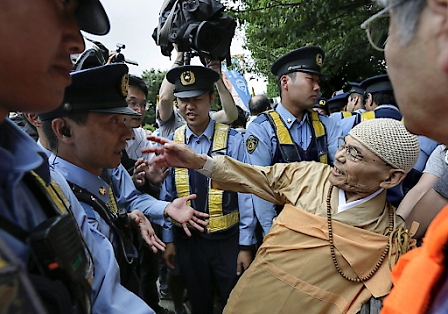 Japanese policemen force to remove a Buddhist demonstrator protesting against security bills outside Japan's parliament in Tokyo, Japan, 16 July 2015 