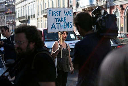 Frau mit Schild "First we take Athens"