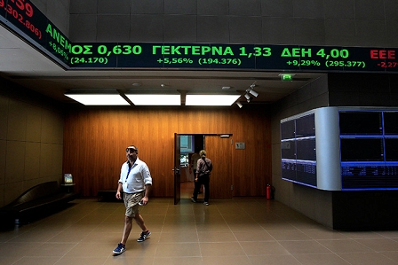 A man walks under an electronic board showing share prices at the Stock Exchange in Athens, Greece, 04 August 2015. Equity prices were falling on 04 August on the Athens Stock Exchange.