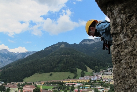 Frau mit Schutzhelm schaut aus Schichtturm auf Eisenerz