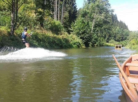 Wakeboarder fährt einen Fluss hinauf/hinunter