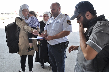 Junge Flüchtlingsfamilie und ein Polizist