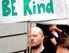 Mann mit "Be Kind" Schild bei Demonstration